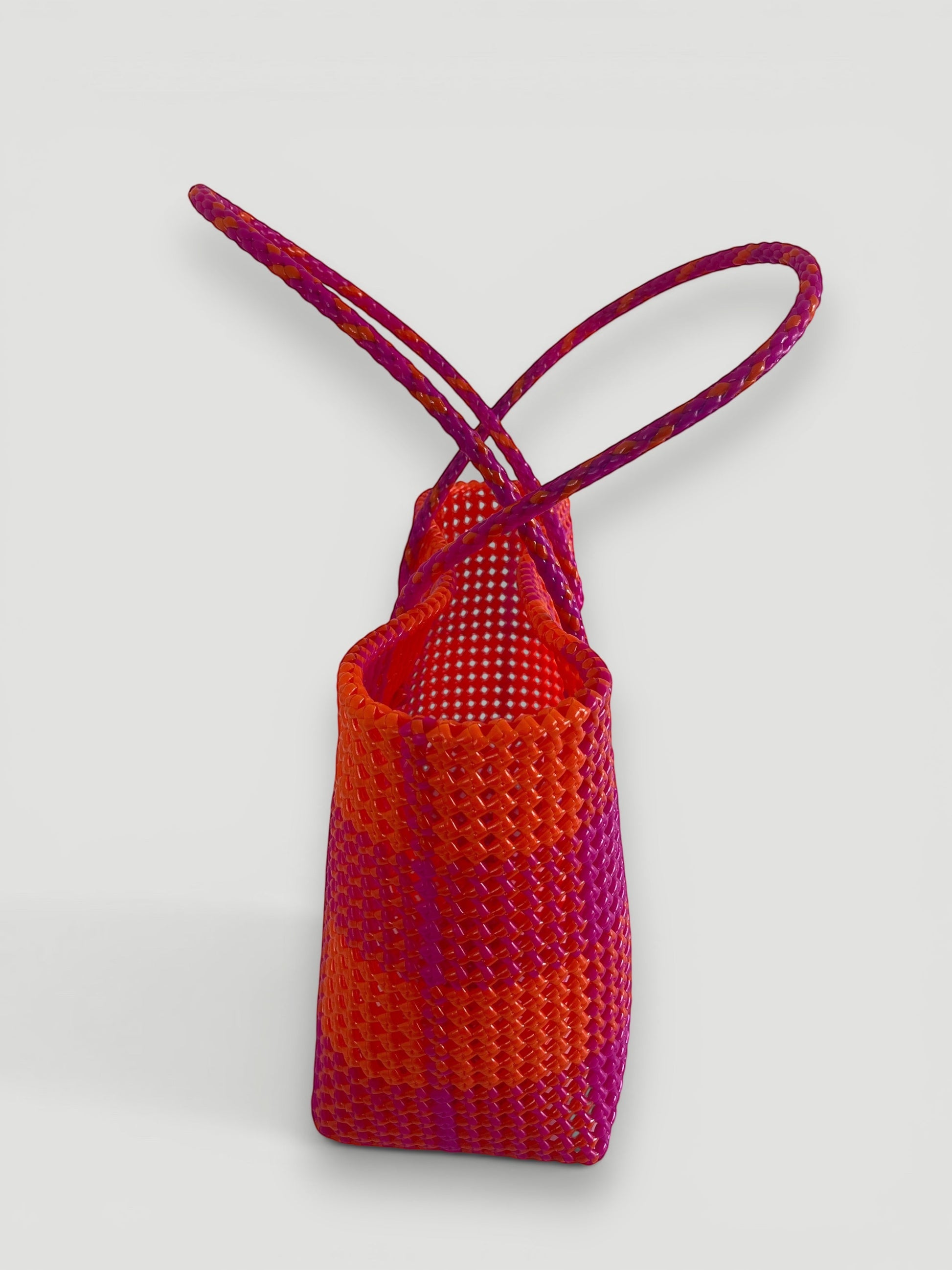 MOKA large hand-woven basket bag in dark pink and orange recycled plastic and silk with braided handles.